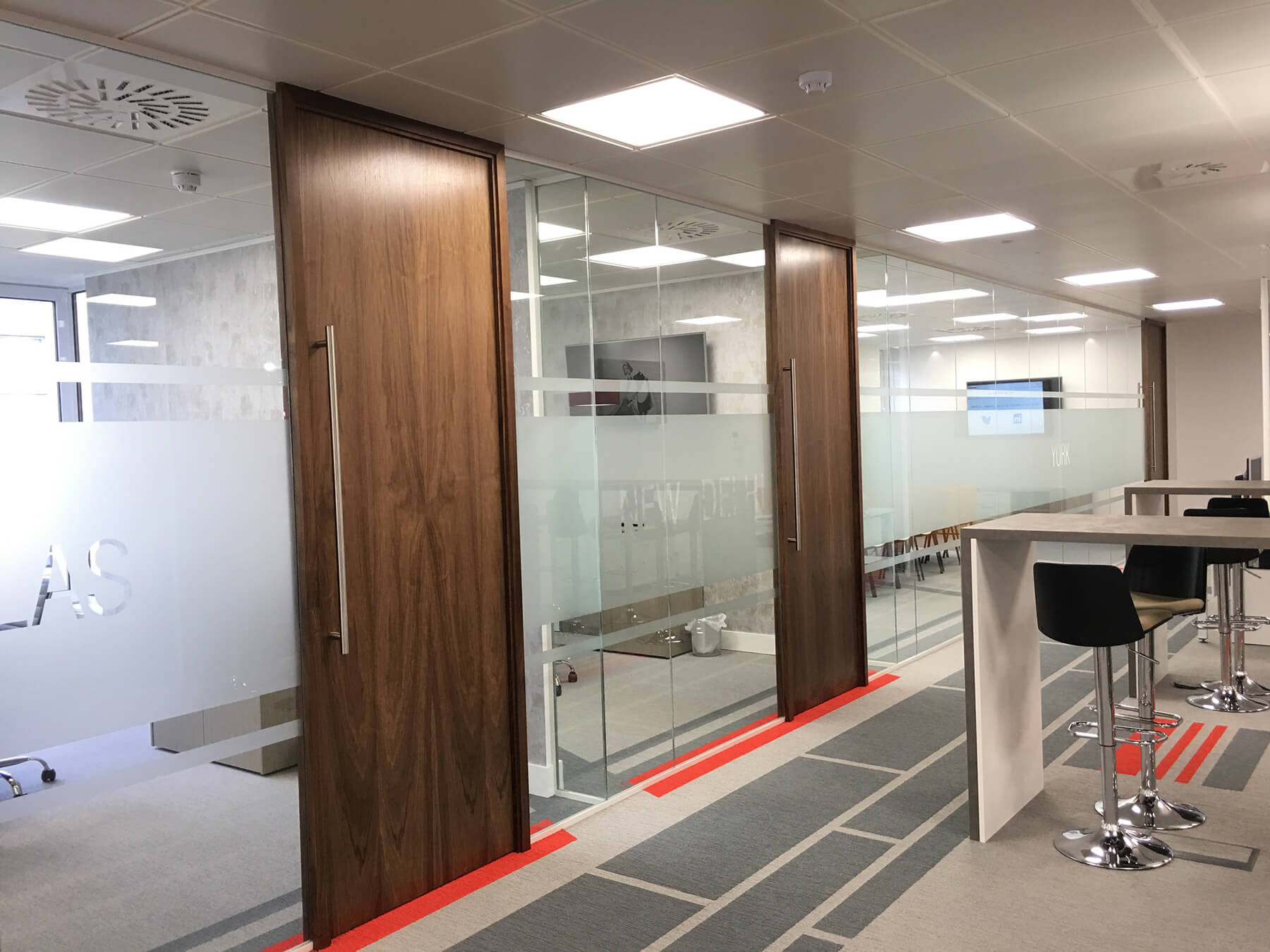 Glass partitions with high solid bands and wood doors Glass partitions with high solid bands and wood doors