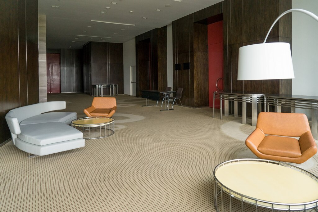Modern hotel lobby with leather sofa chairs lamp round tables