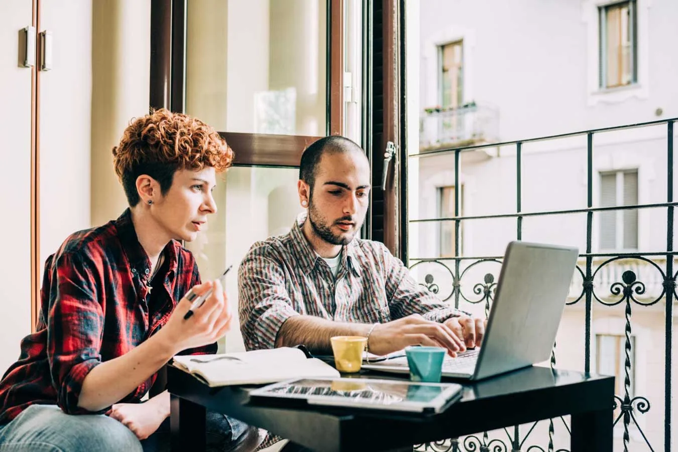 Two people looking away using technological device 