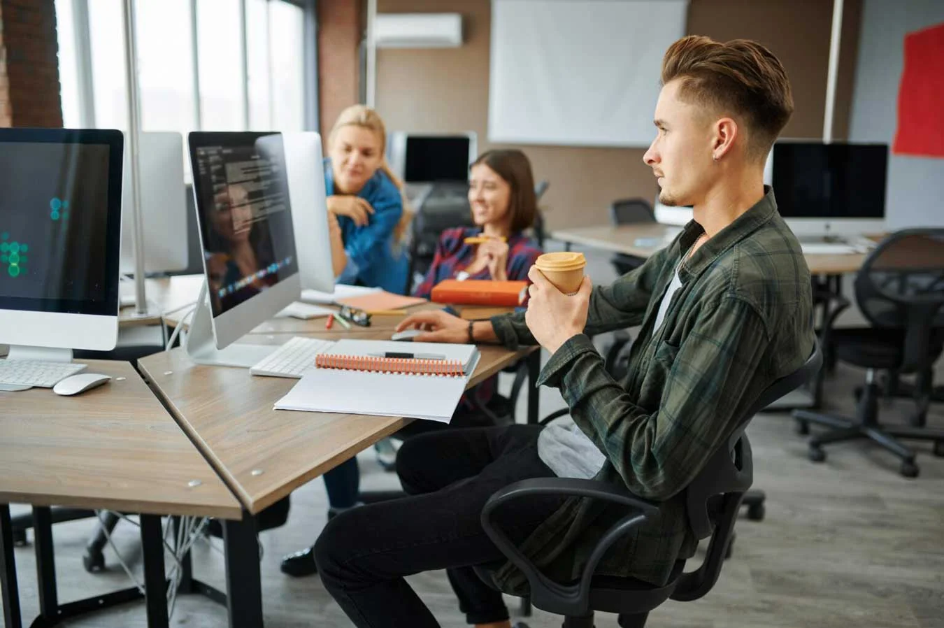 Young it specialists works on computers in office